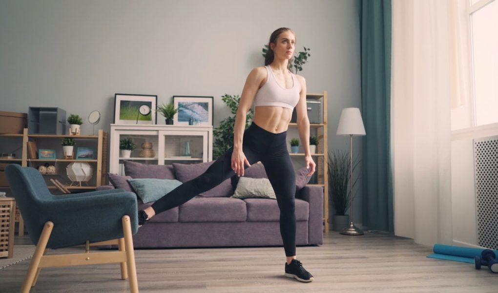 a woman in a sports bra top and leggings in a living room