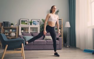 a woman in a sports bra top and leggings in a living room