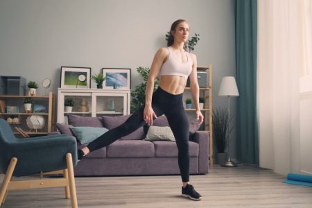 a woman in a sports bra top and leggings in a living room