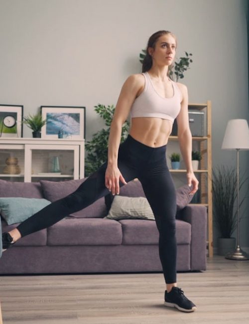 a woman in a sports bra top and leggings in a living room
